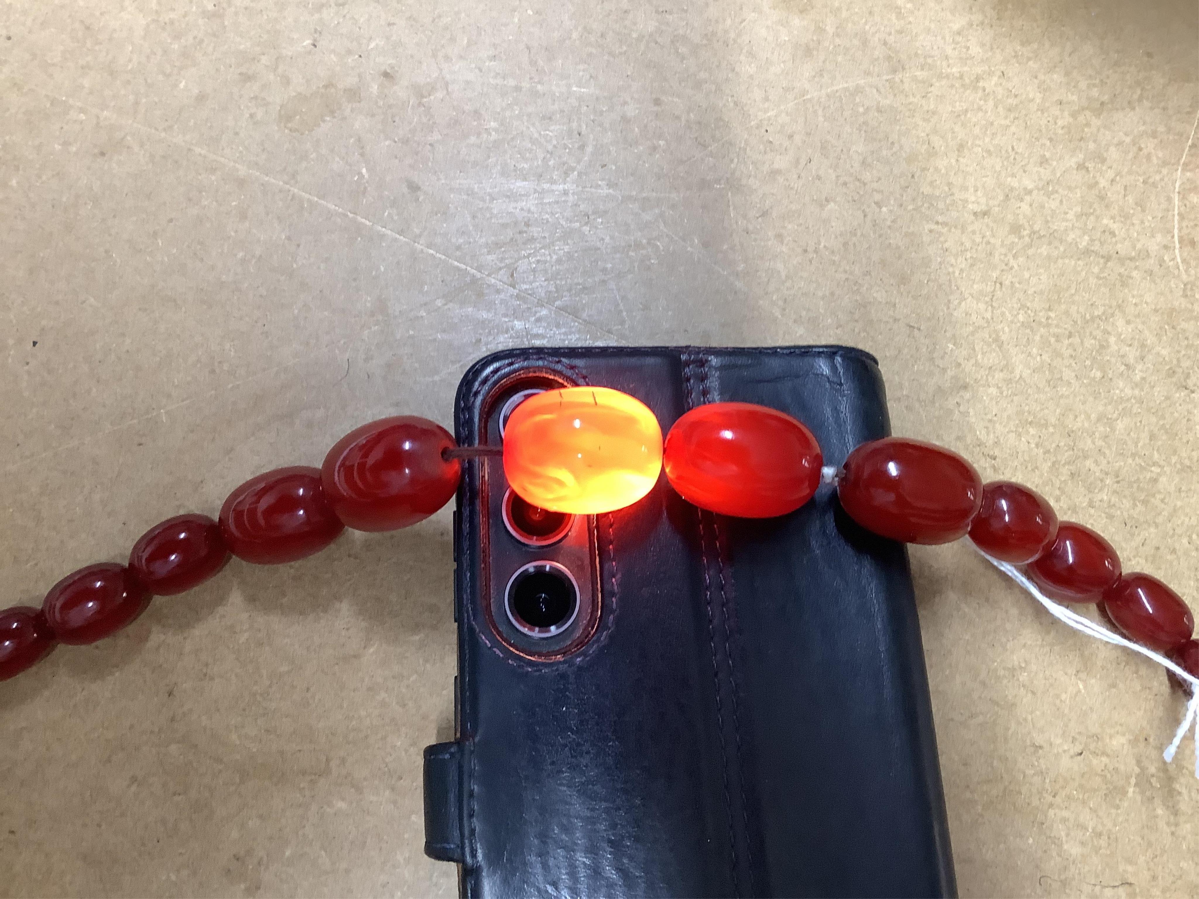 A single strand graduated simulated cherry amber bead necklace, 76cm, gross weight 75 grams.